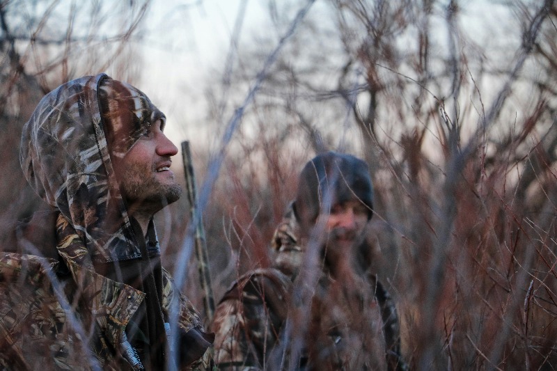 Family Hunting Trips: A father and sun share a prized moment as they track an elk while hunting in Idaho.