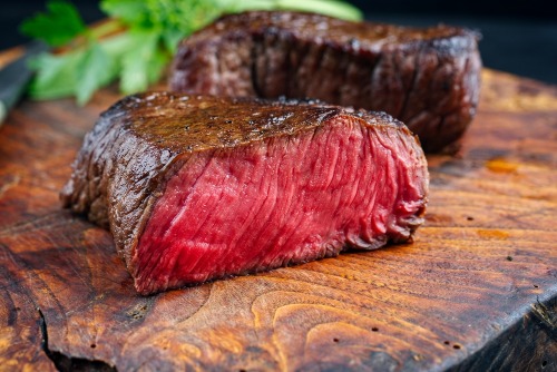 How to Cook Buffalo Meat: A freshly cooked buffalo steak on a wood chopping board.